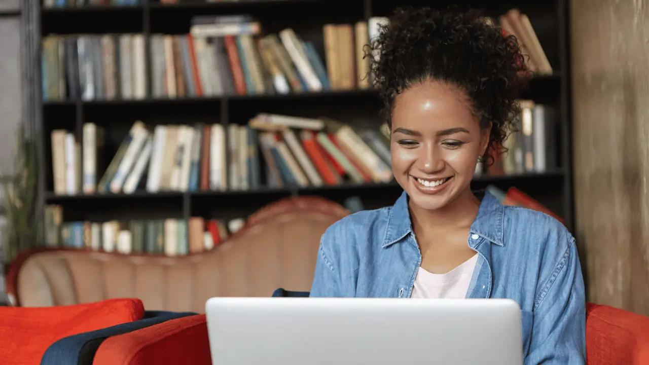 Mulher sorrindo em frente a um notebook