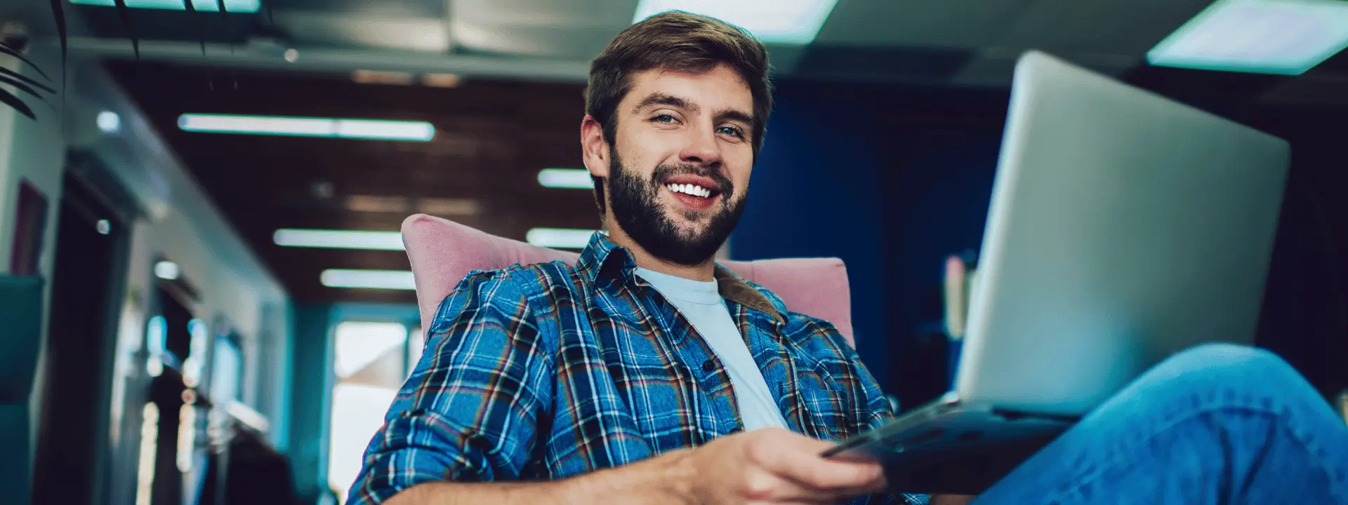 Homem sorridente em frente ao computador
