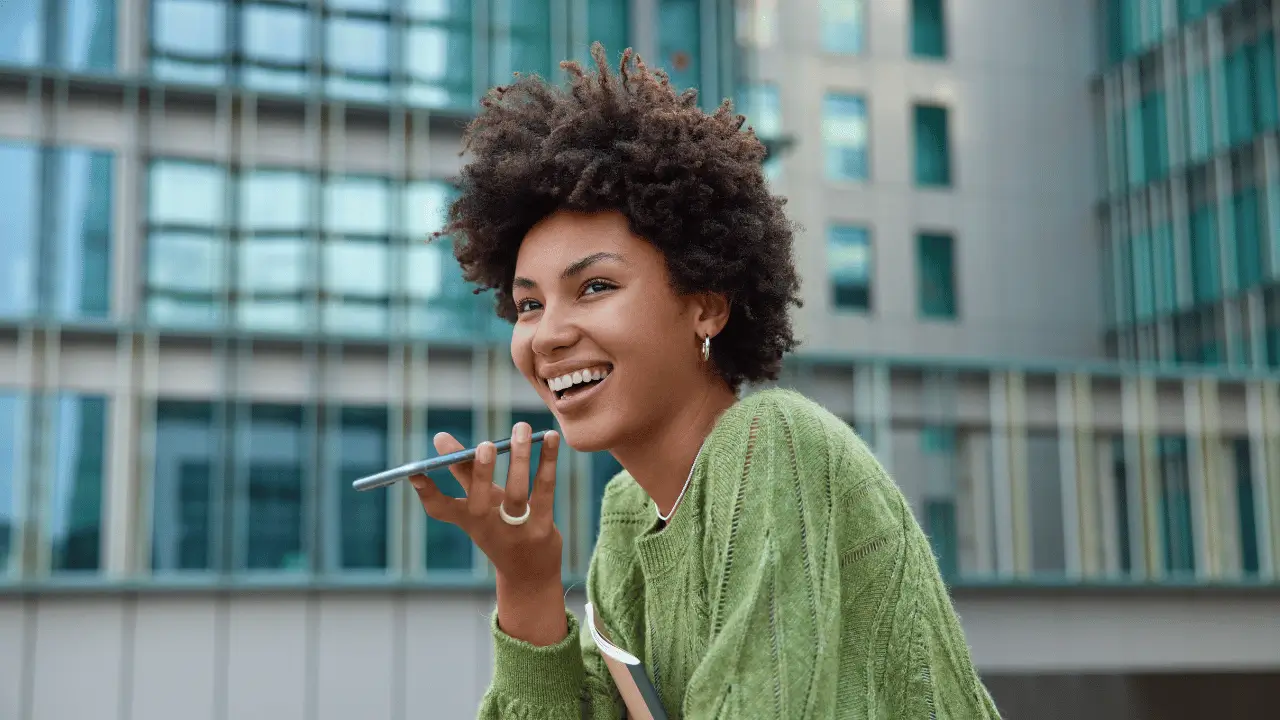 Mulher negra sorrindo falando ao celular