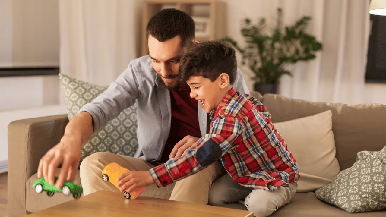 Homem e filho brincando no sofá