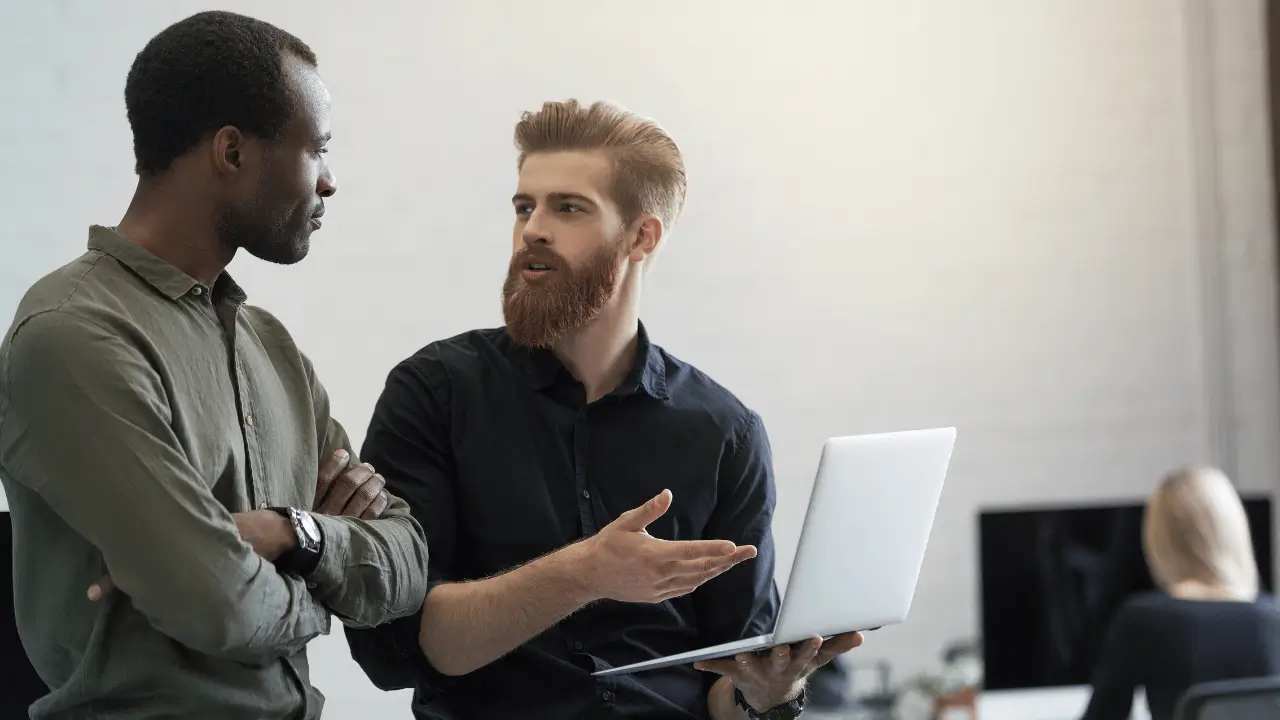 Dois homens observando algo na tela de computador