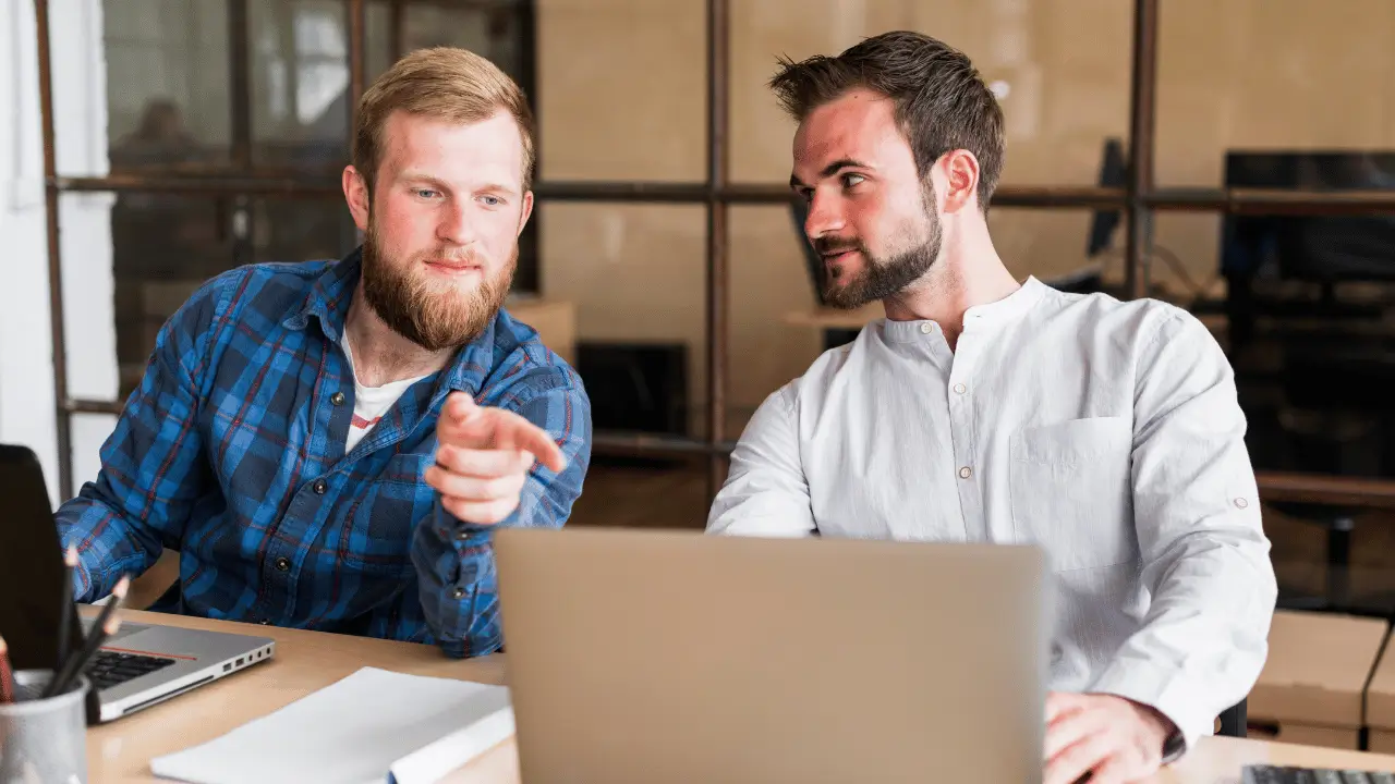 Dois homens observando algo na tela de computador